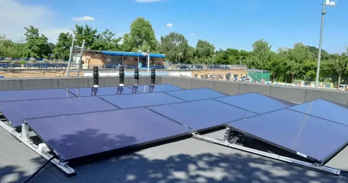 Solar panels installed on roof of swimming pool in summer